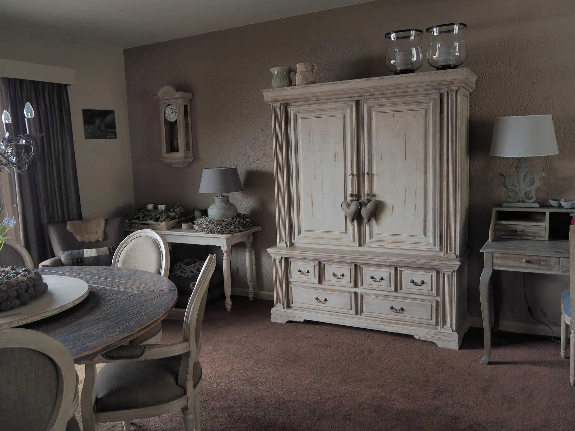 Woonkamer met een vergrijsde kast, tapijt en overgordijnen